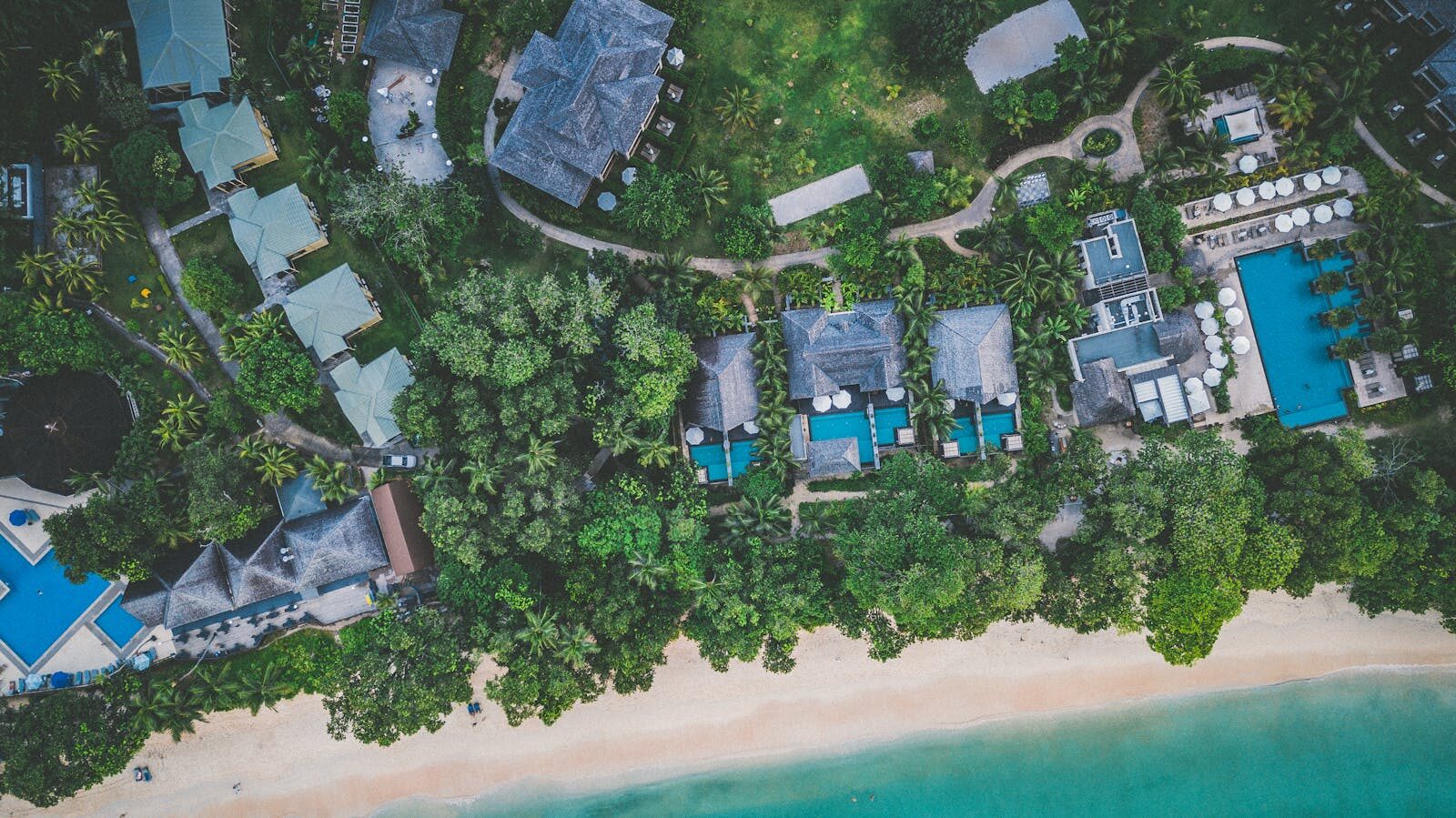 Stunning aerial view of a beachfront resort surrounded by lush greenery in Beau Vallon, Seychelles.